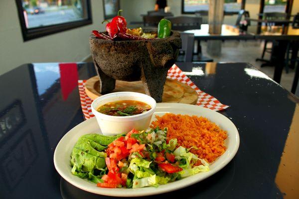 This is our molcajete with a side of charro beans, aguacate, salad and Mmexican rice