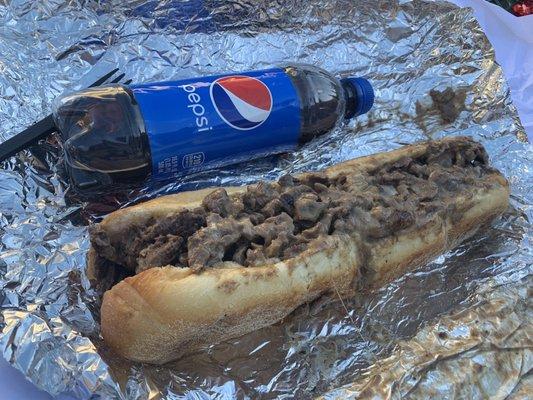 Philly cheese. Used a coke bottle to show the size of the sandwich. Sandwich is huge but meat is too thick.