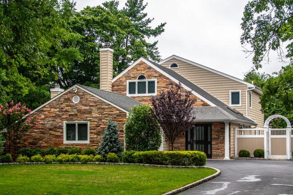 Charter Oak vinyl siding by Alside with Boral cultured stone masonry accents. GAF Weatherstopper Roofing System with Golden Pledge warranty.