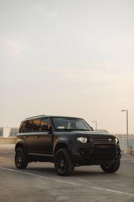 Defender 110 wrapped in Satin Black and bumpers painted in Gloss Black