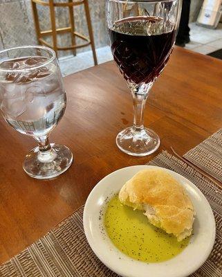 A little House Red wine and a warm roll with seasoned olive oil.