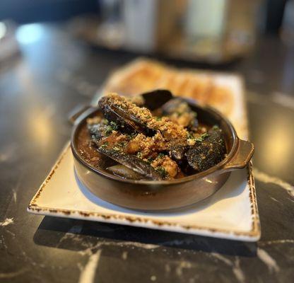 Mussels: Chilean Blue Mussels Sauteed in a Gajun Garlic Sauce Topped w/ House-made Pork Belly. Baked Crostini's | $12.99