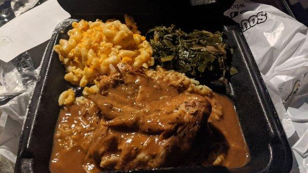 Baked chicken with gravy, yellow rice, collard greens, and Mac and cheese