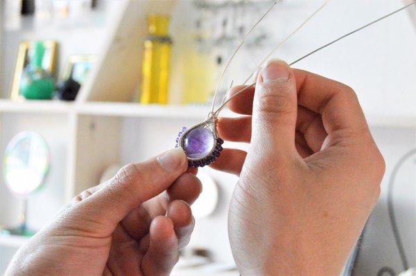 Co-owner George wire wrapping an Amethyst bead