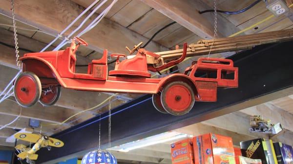 Vintage toys hang from the ceiling, like this Buddy-L 1932 fire truck.