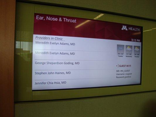 Digital announcement board by the clinic entrance.