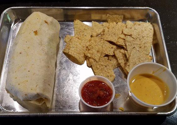 large breakfast burrito with tortilla chips, salsa, and cheese sauce