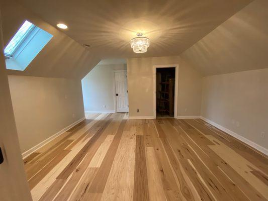 Upstairs bedroom, pre-furniture, on a plywood subfloor.