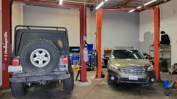 Subaru and Jeep Wrangler getting serviced.