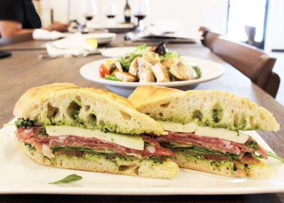 Italian Pesto Sandwich - Spicy salami and prosciutto with mozzarella, tomatoes, and arugula on a freshly baked baguette