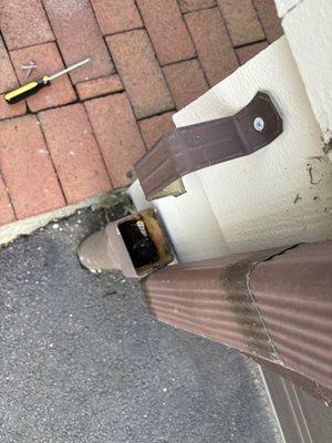 Clogged gutter causing water to flood onto walkway and into garage