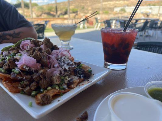 Right drink is a cherry mezcal cocktail, other is a Cadillac marg, and those delicious brisket nachos