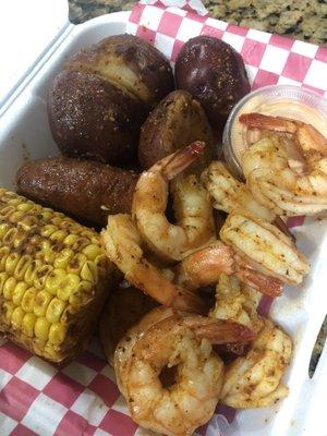 shrimp basket with boiled corn, sausage, and potatoes