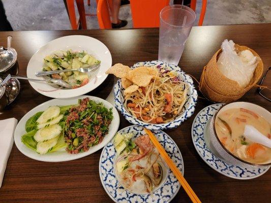 Cucumber salad, papaya salad, beef laab, and tum yum soup with sticky rice.