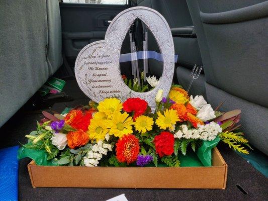 Beautiful flowers and memorial garden stone that has a wind chime