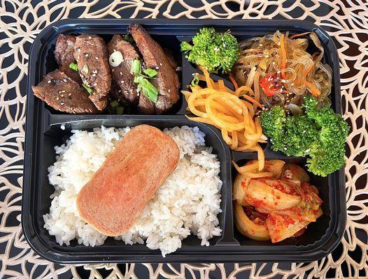 Sunny's Bento w/ galbi steak, spam, kimchi, japchae, sesame broccoli, radish kimchi | $19.85