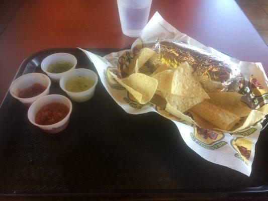 Steak Burrito hidden behind the complimentary chips and a selection of sweet salsas