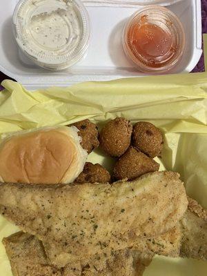 Tilapia plate with hush puppies, roll, hot sauce and tater sauce