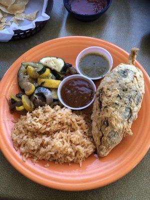 Chicken fried brisket stuffed Chile rellano with green and red sauce, rice & grilled veggies.