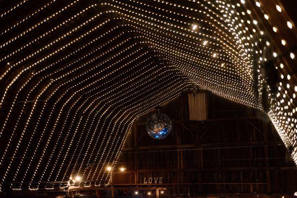 Our custom ceiling lights inside our Reception Barn. Very romantic, if we do say so ourselves. Courtesy of Honeyroot Studio.