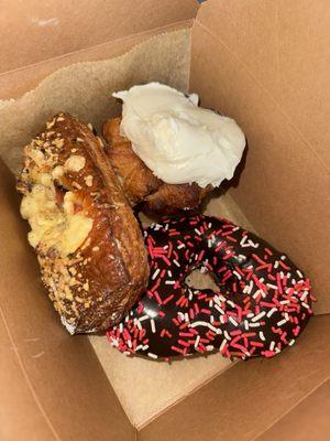 Monkey pull apart bread with cream cheese frosting, chocolate frosted donut with sprinkles, savory danish