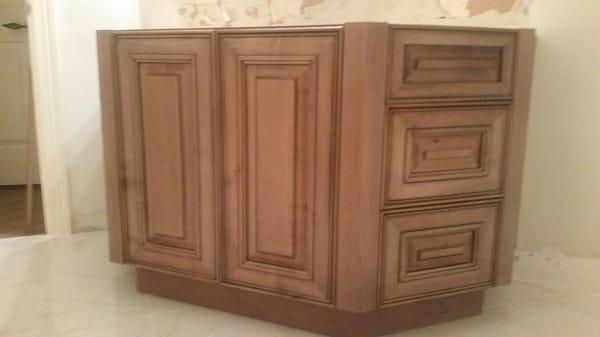 custom angled cabinet, doors in the front and 3 drawers on either side. Westheimer doors