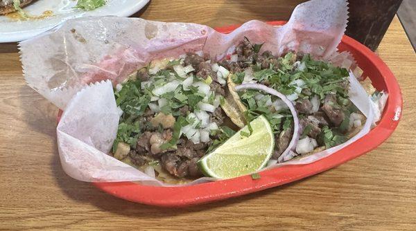 2 Steak tacos with onions, cilantro and lime.