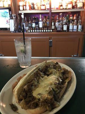 Steak hoagie and soda with lime.