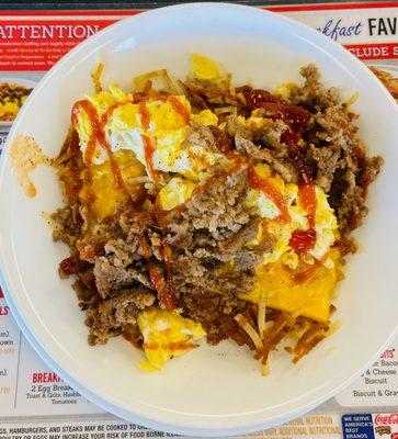 A bowl of hash browns, sausage, and eggs.