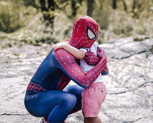 Spider man hugging the bday boy.