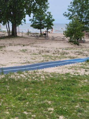 Path to beach, picnic tables with grills.