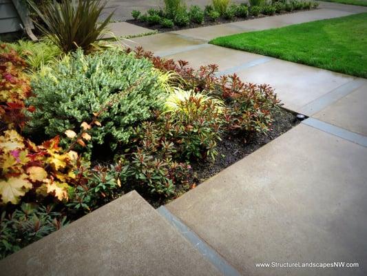 Complete Design/Build: Custom Poured Concrete Pavers with Bluestone inlay and plantings.