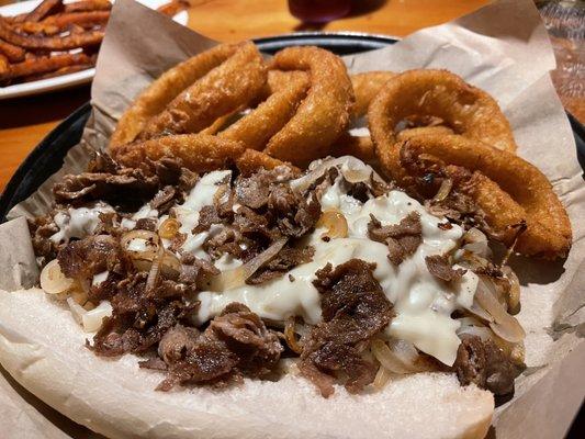 Philly steak with cheese, fried onions, and onion rings