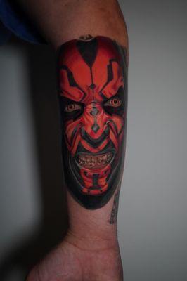 This Darth Maul tattoo captures his menacing gaze and fierce expression with bold colors, bringing the Sith Lord to life.