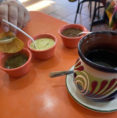 Chips with 3 different salsas and a black coffee.