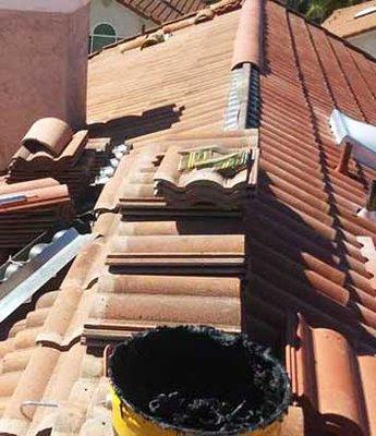 Performing a tile lift and lay which is a roof replacement of the underlying roof paper to prevent roof leaks