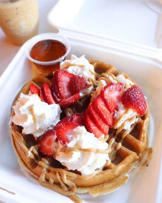 Gluten free waffle with strawberries, whipped cream, and peanut butter