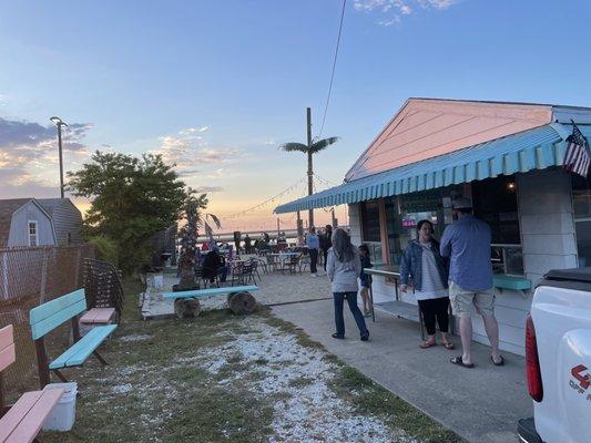 This place absolutely is open. We had burgers and beer at picnic table by the water, and enjoyed a live guitar player also.