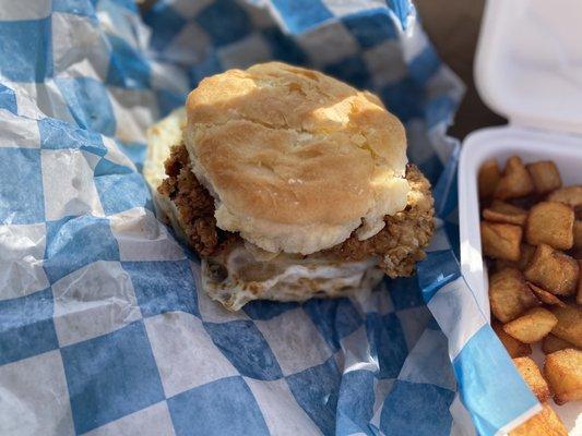 Fried egg & cheese w/ fried chicken thigh on a biscuit! Home fries on the side