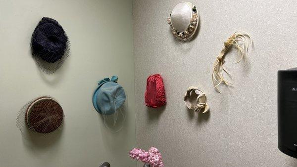 Decor of vintage hats in ladies' room.