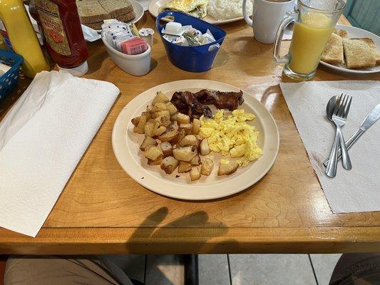 One egg scrambled with bacon and breakfast potatoes.