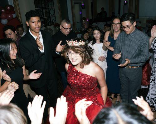 Quinceañera dancing around a group of people