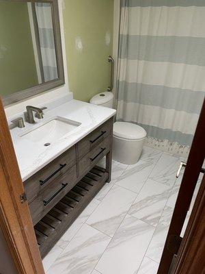 Guest bath with new vanity, quartz top and flooring