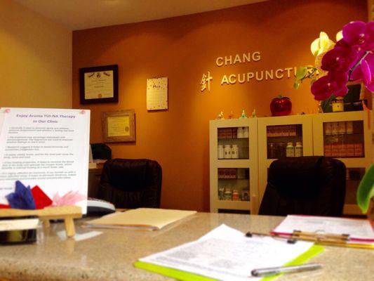 Front desk. Herbs stored nicely in cabinet. Business license displayed to the left along with a treatment price.