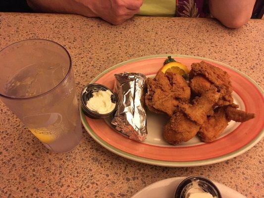 Half fried chicken, drink glass for scale.