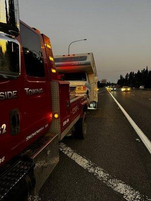 RV hooked up to a tow truck.