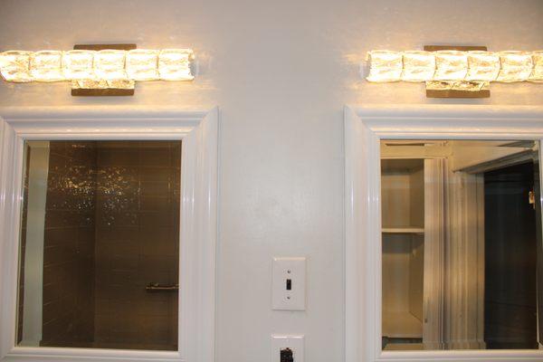 mirror hanging on wall.
 Install New Light Fixture On wall.