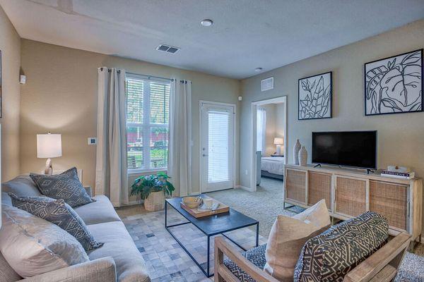 a living room with a couch and a television at Spring Creek Apartments