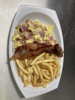 Revuelto con jamón dentro y tocino al lado y papas fritas  Scrambled with ham mixed in and bacon on the side and French fries