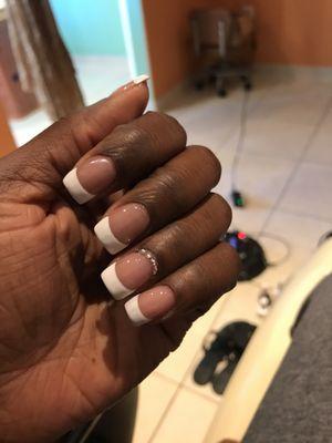 Shellac French nails with a row of rhinestones around cuticle line